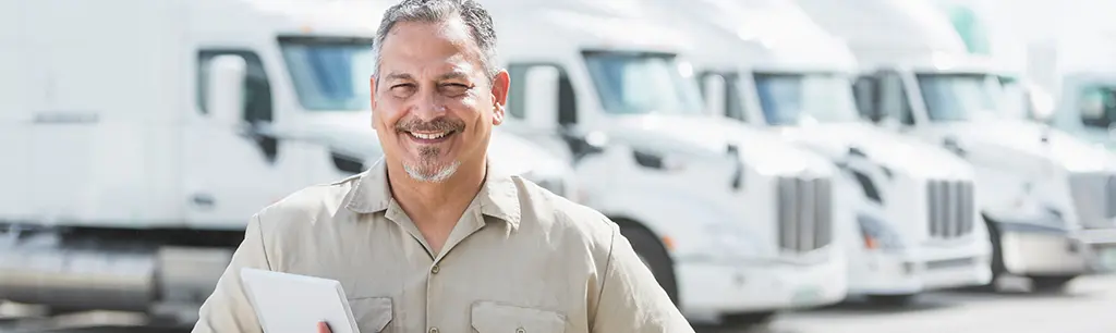 gentlemen smiling, semi trucks in background