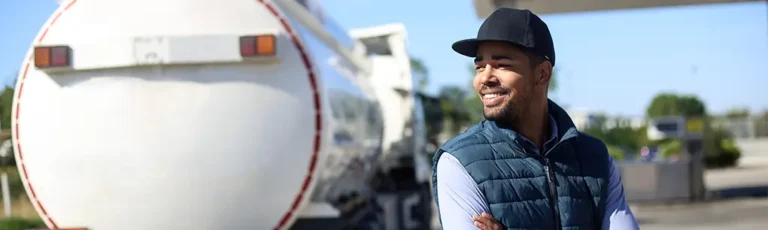 Gentlemen smiling, gas tanker in background